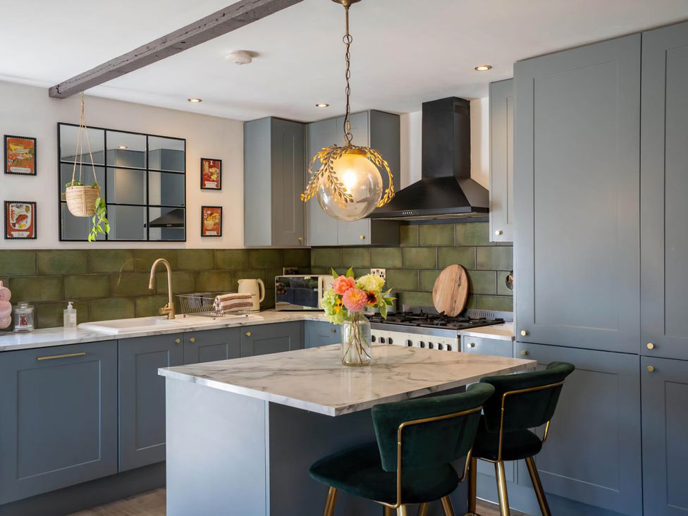 A kitchen with cabinets and an island at Foxley Lodge in Norwich