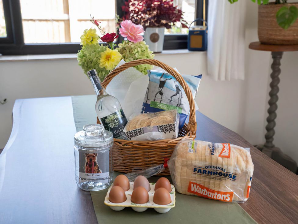 A basket with wine, bread, and eggs on a table at Foxley Lodge in Norwich