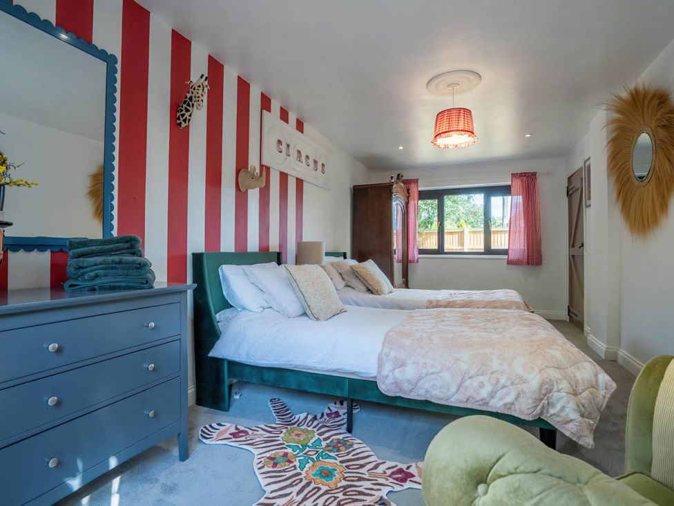 A bedroom with two beds and a dresser at Foxley Lodge in Norwich