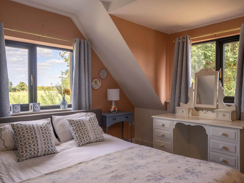 A bedroom with a bed and dresser at Foxley Lodge in Norwich