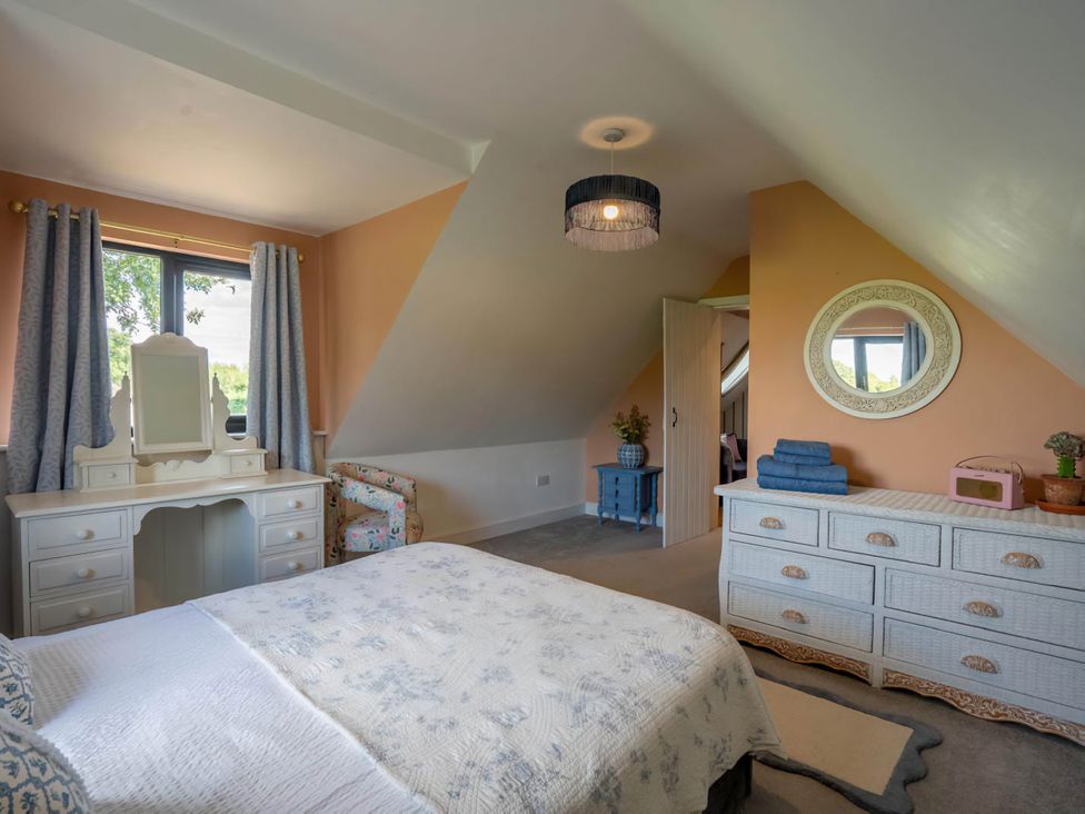 A bedroom with a bed and vanity at Foxley Lodge in Norwich