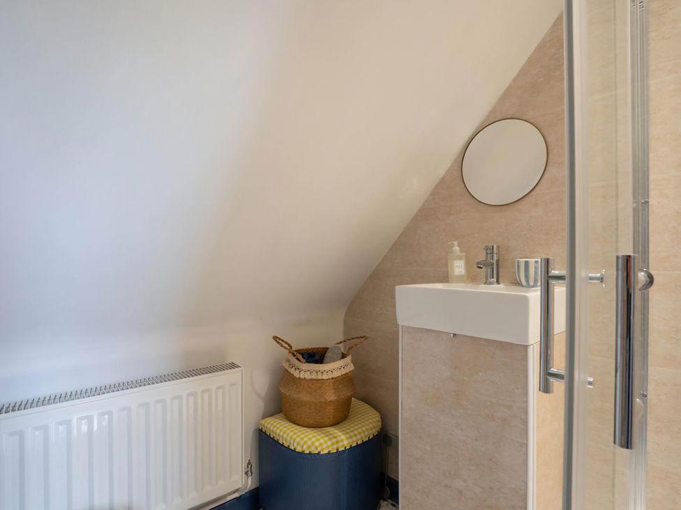 A bathroom with a washbasin and a mirror at Foxley Lodge, Norwich
