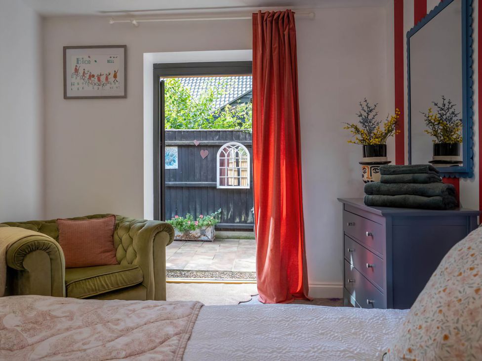 A bedroom with a sofa and window at Foxley Lodge Norwich