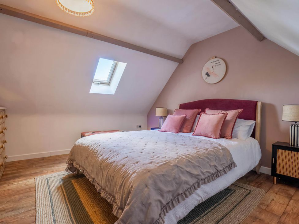 A bedroom with a bed and dresser at Foxley Lodge in Norwich