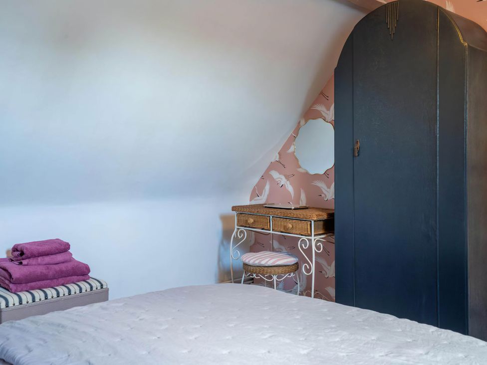 A bedroom with a bed and wardrobe at Foxley Lodge in Norwich