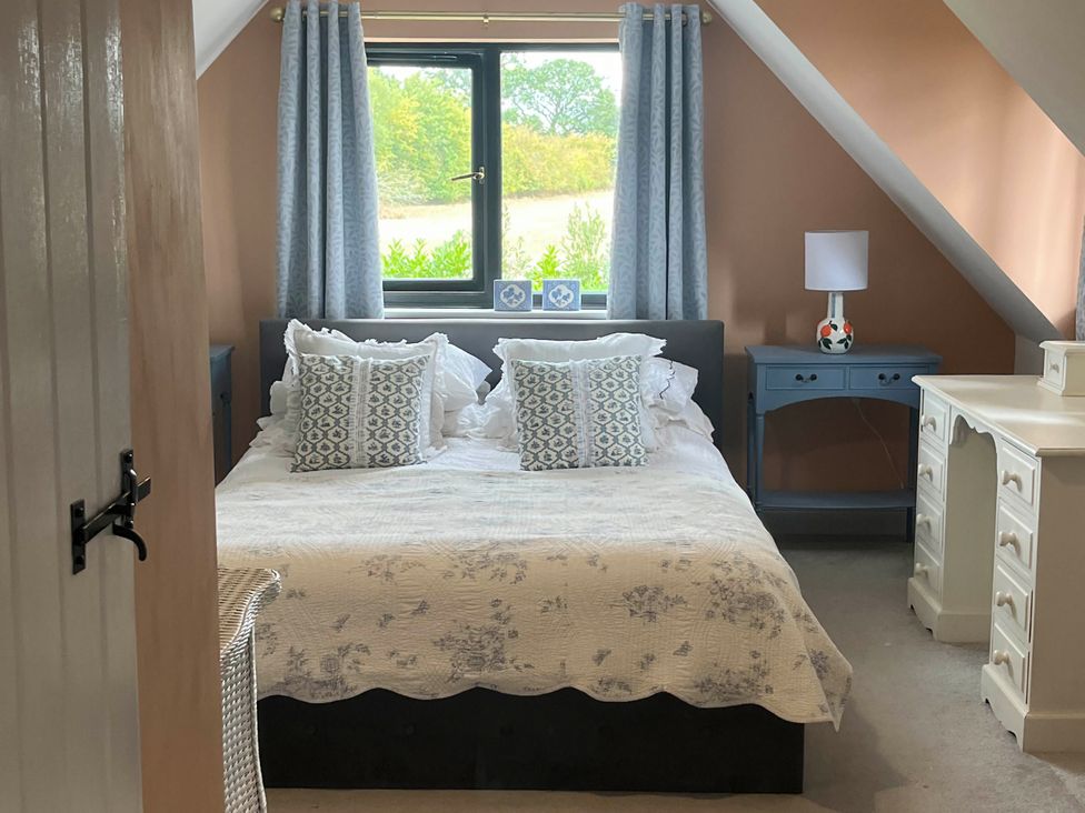 A bedroom with a bed and dresser at Foxley Lodge in Norwich