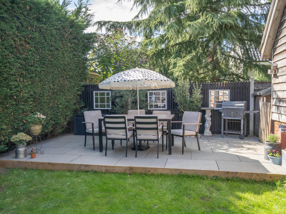 A garden with a table and chairs under an umbrella at Foxley Lodge Norwich
