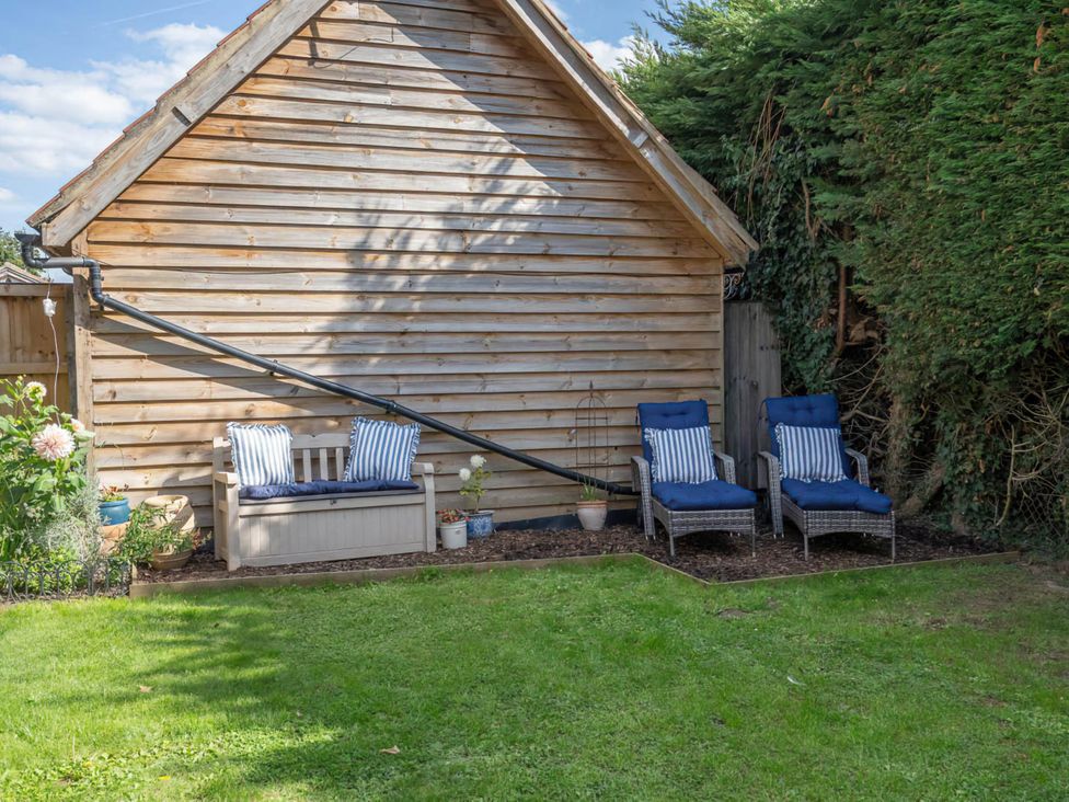 A garden with a wooden wall and seating at Foxley Lodge in Norwich