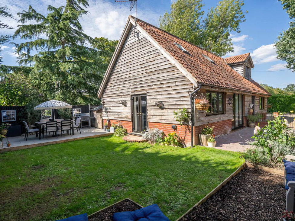 A garden with a house and patio furniture at Foxley Lodge in Norwich