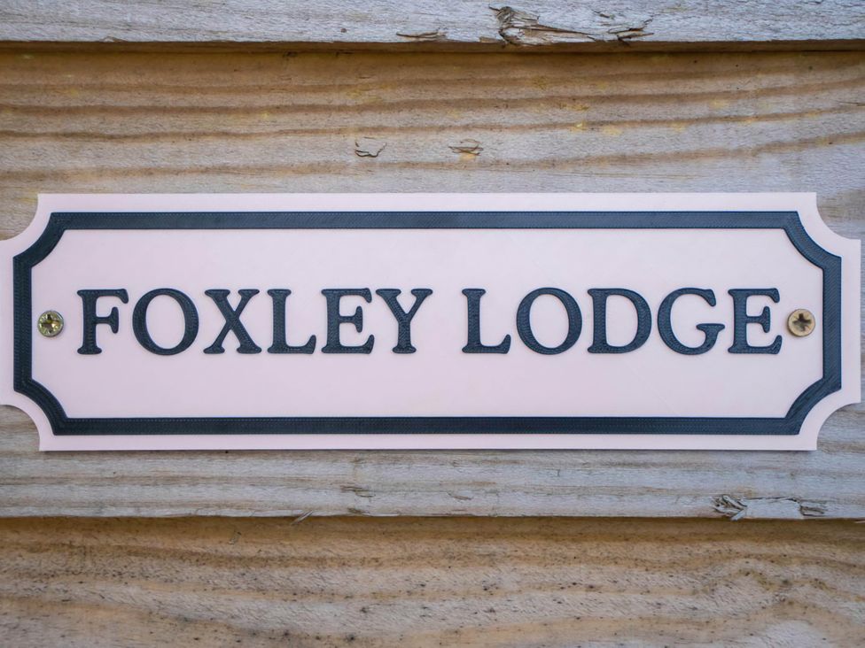 Nameplate for Foxley Lodge on a wooden surface in Norwich