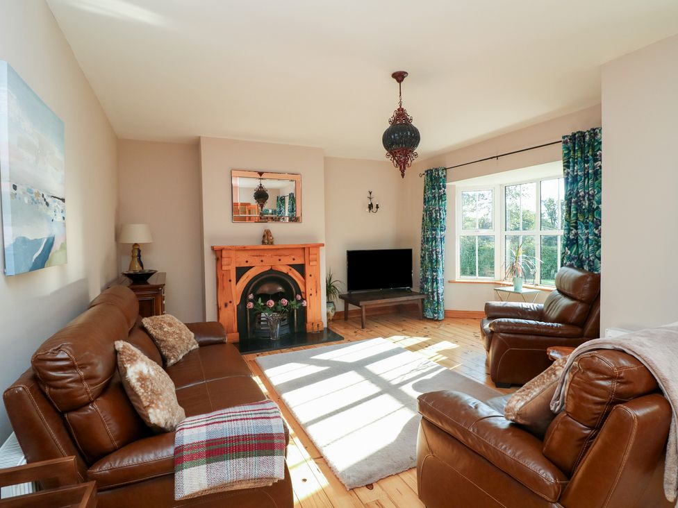 A living room with a fireplace and sofa at The Lodge Bolinahaney, Bunclody, County Wexford