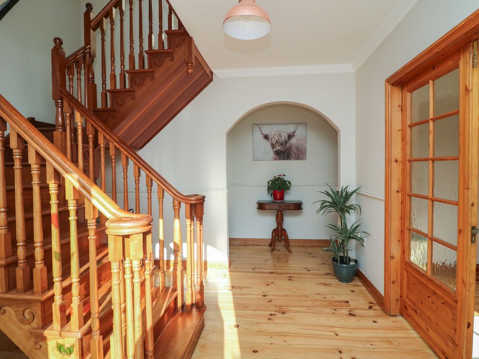 A hallway with a staircase and a table at The Lodge Bolinahaney in Bunclody, County Wexford