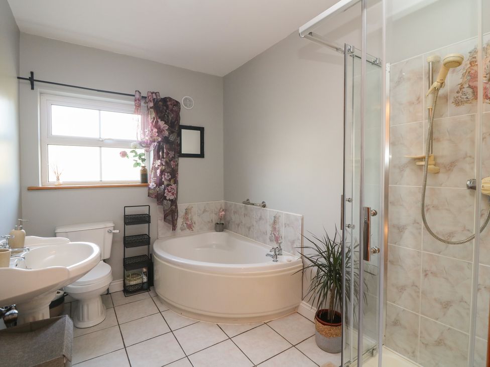A bathroom with a bathtub, sink, toilet, and shower at The Lodge Bolinahaney in Bunclody, County Wexford