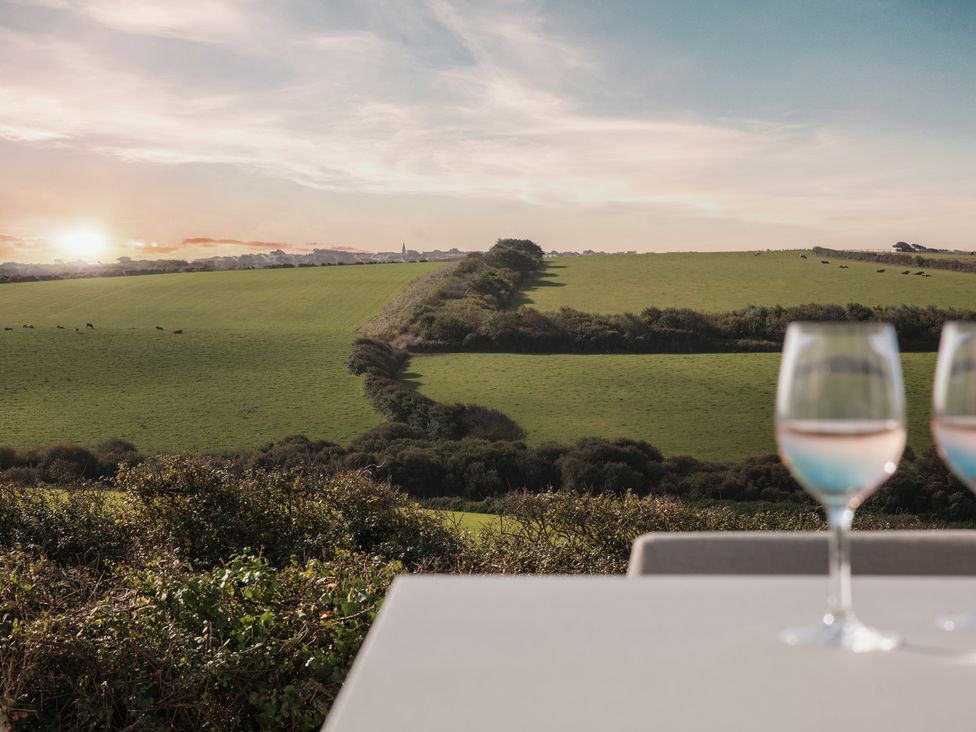 A view of a green field with glasses on a table at Polview in Newquay