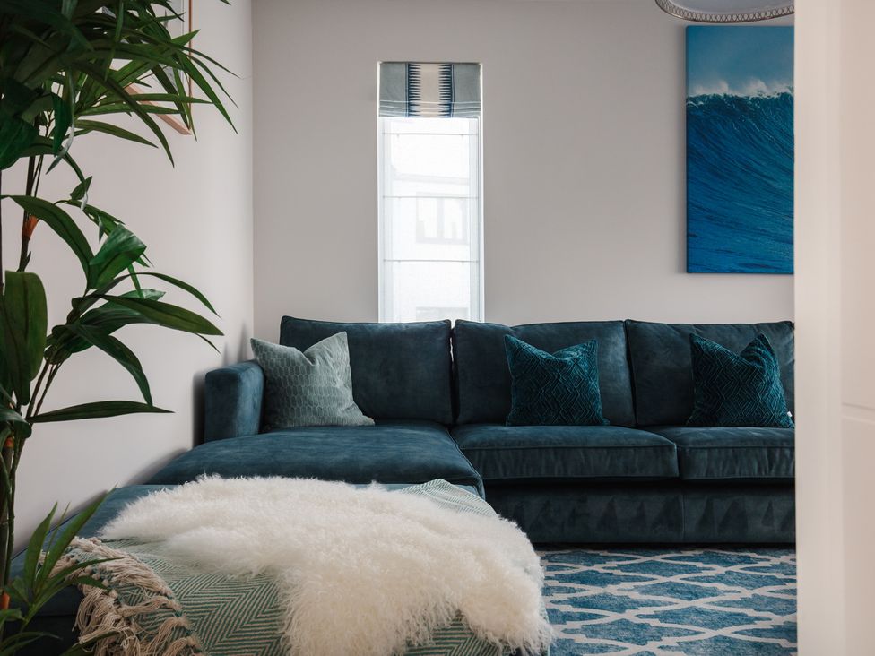 A living room with a sofa and cushions at Polview in Newquay