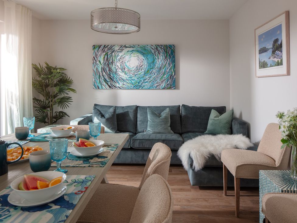 A dining room with a table and sofa at Polview in Newquay