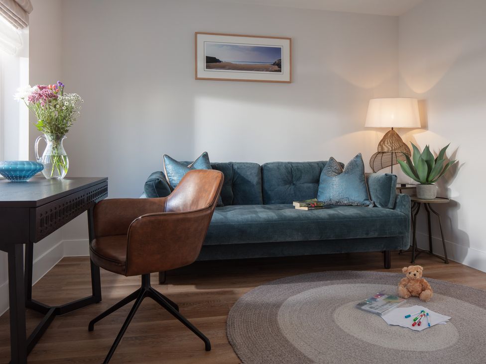 A living room with a sofa and a chair at Polview in Newquay