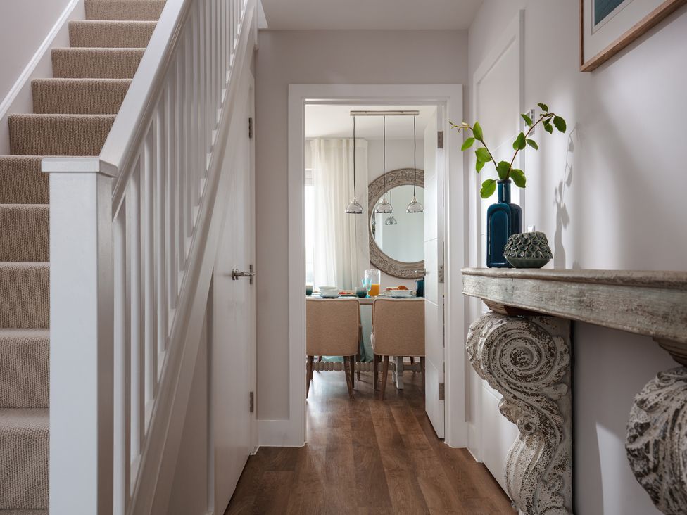 A hallway with stairs and dining area at Polview in Newquay