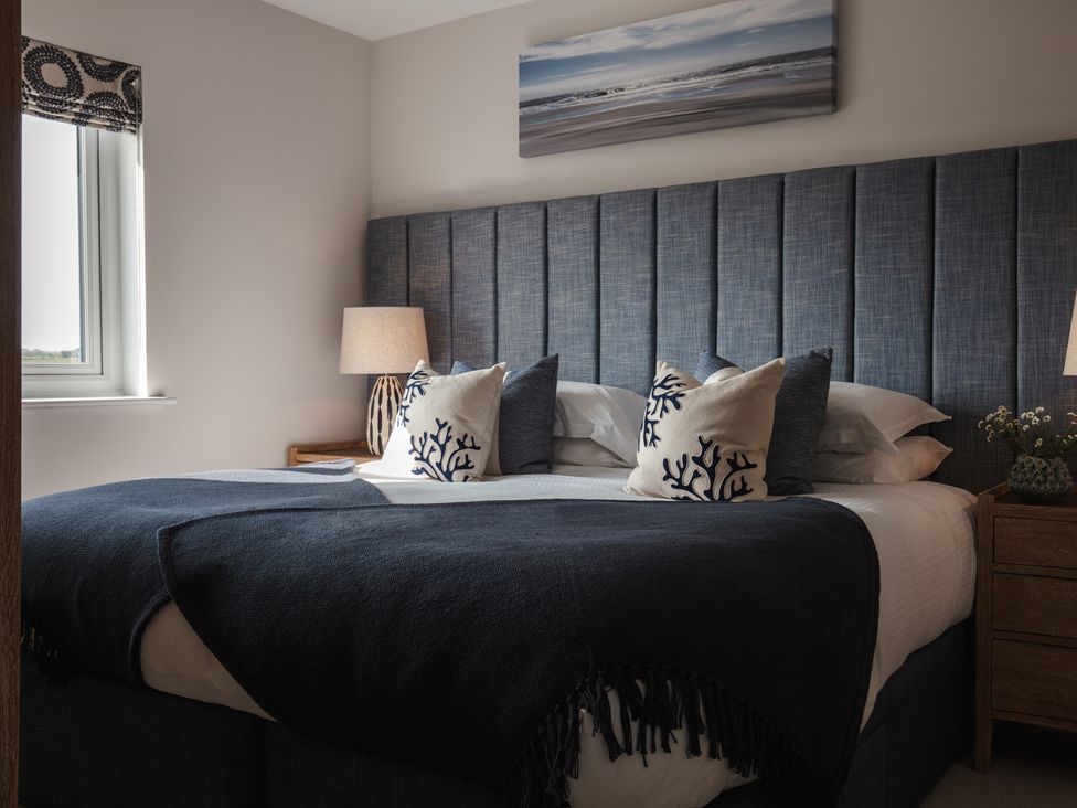 A bedroom with a bed and bedside lamp at Polview in Newquay