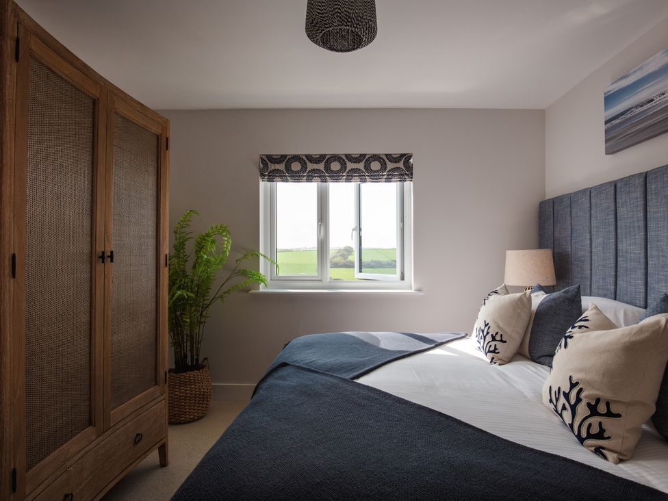 A bedroom with a bed and wardrobe at Polview in Newquay