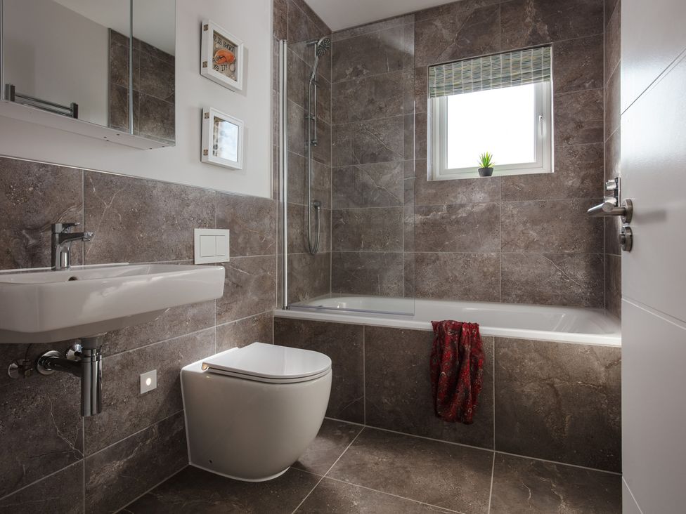 A bathroom with a sink, toilet, bathtub, and shower at Polview in Newquay