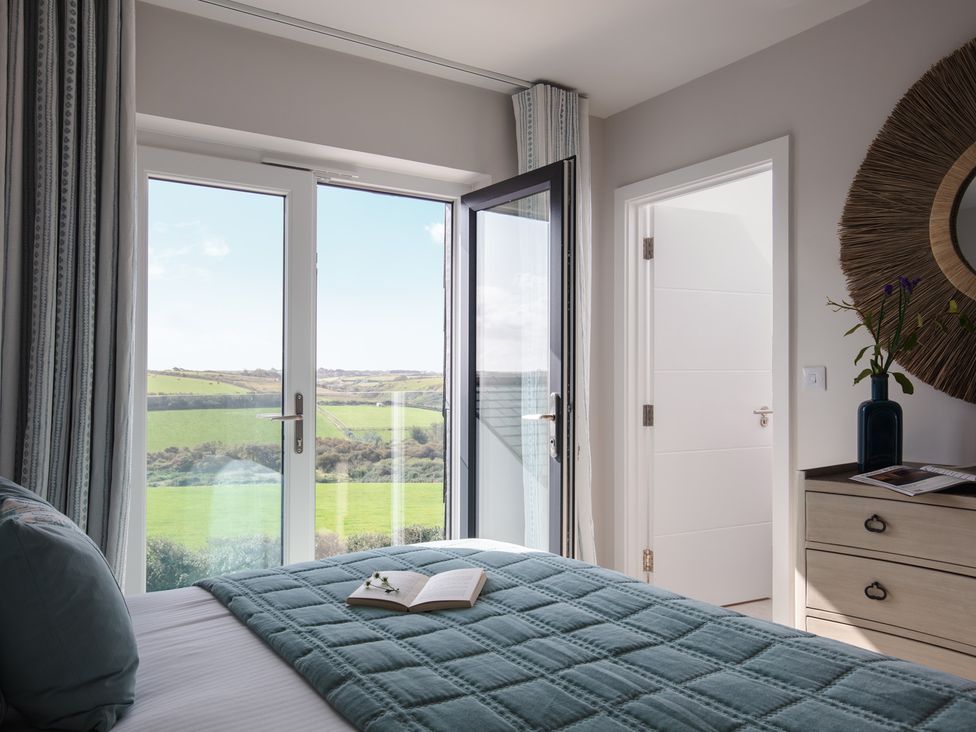 A bedroom with a bed and a book on a quilt at Polview in Newquay