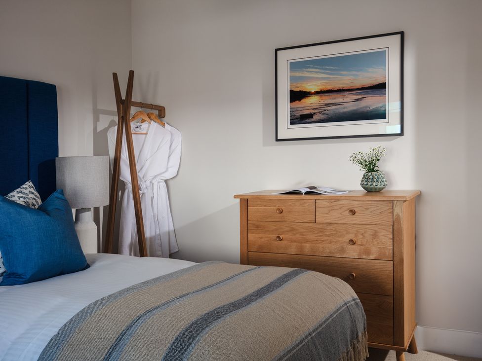 A bedroom with a bed and dresser at Polview in Newquay