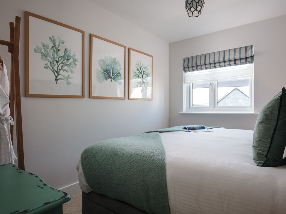A bedroom with wall art and a bed at Polview in Newquay