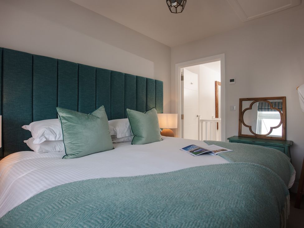 A bedroom with a bed and a mirror at Polview in Newquay