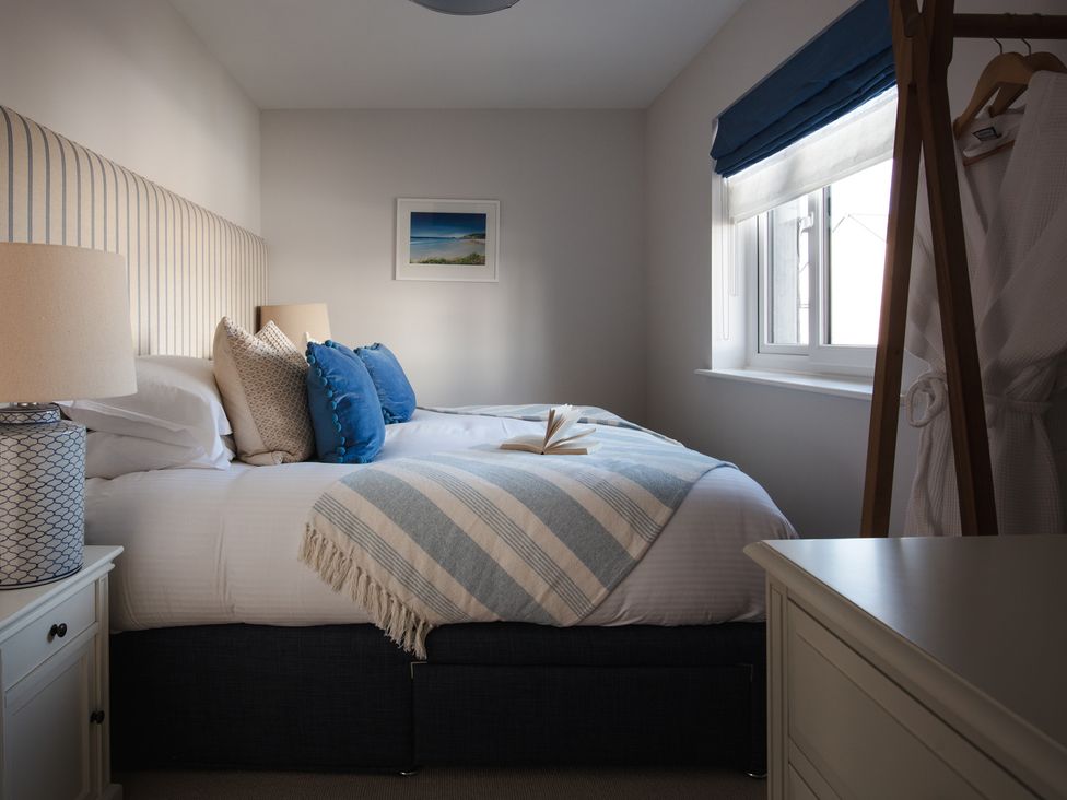A bedroom with a bed and nightstand at Polview in Newquay