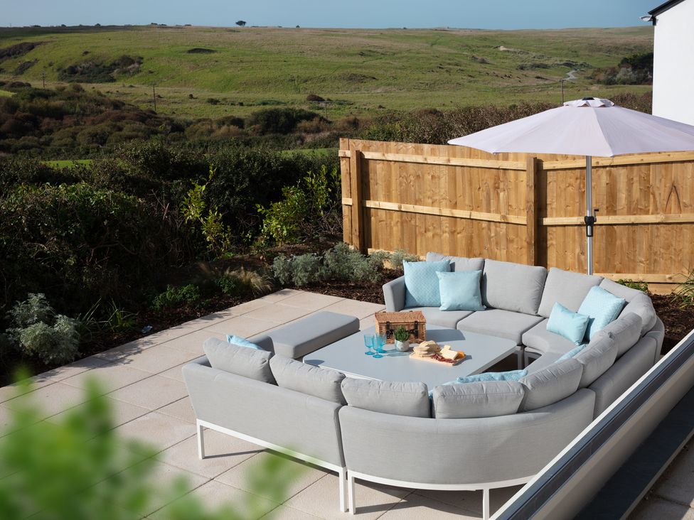 An outdoor seating area with a sectional sofa and table at Polview in Newquay