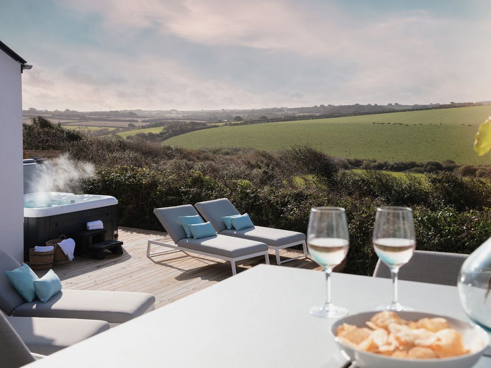 An outdoor space with a hot tub and lounge chairs at Polview in Newquay