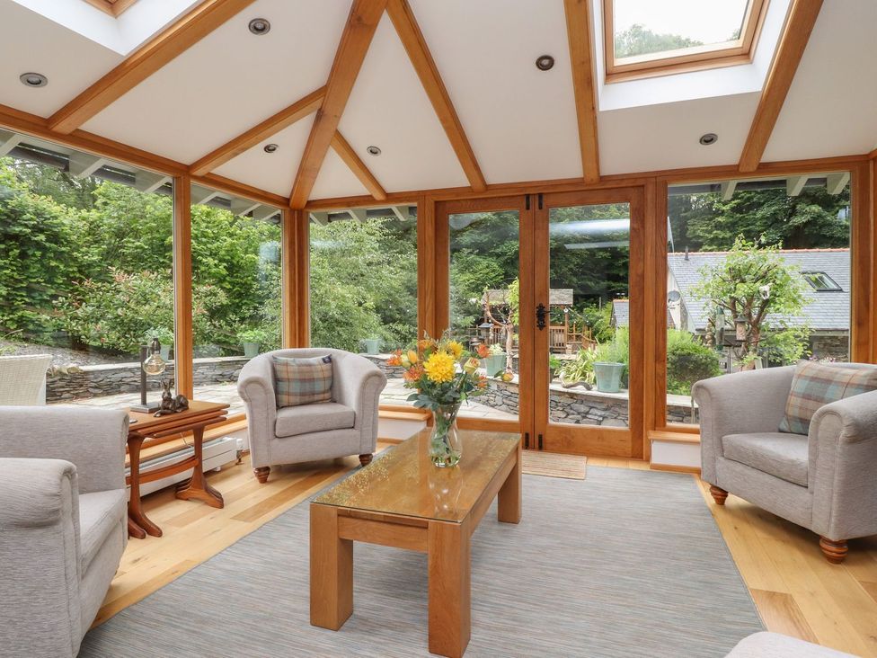 A conservatory with seating and a table at Bobbin Mill Cottage in Ulverston