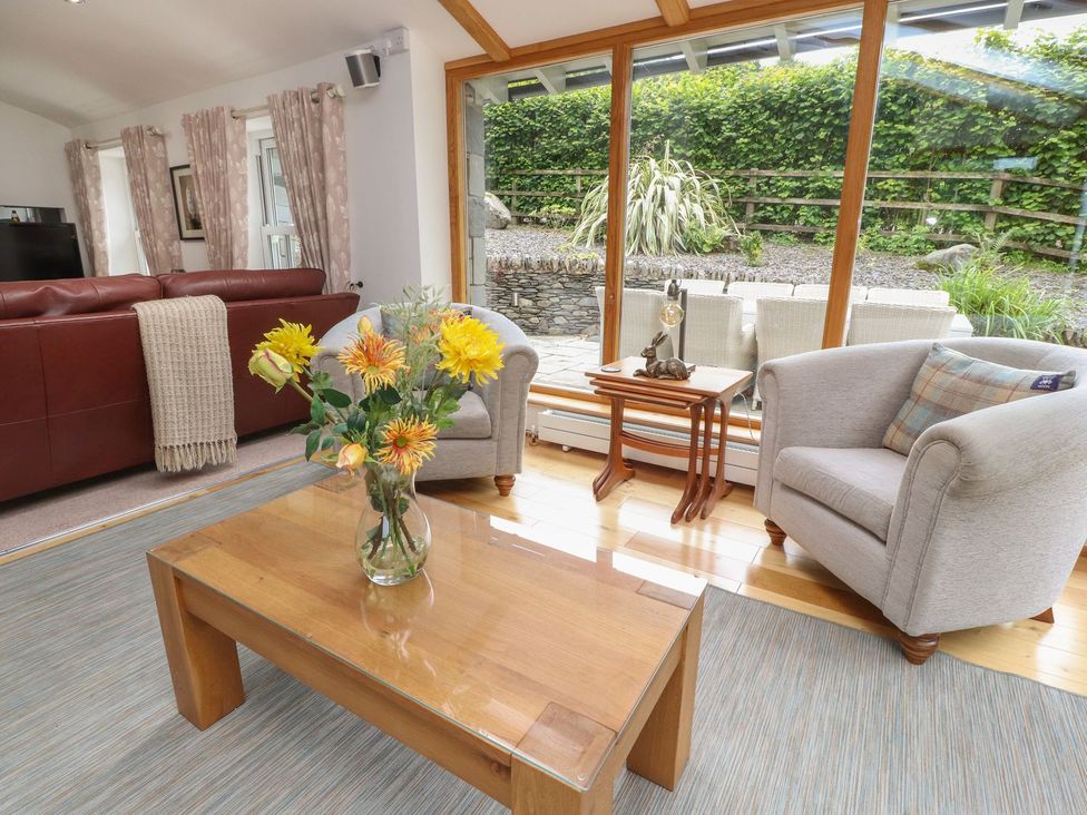A living room with a sofa and armchair at Bobbin Mill Cottage Ulverston