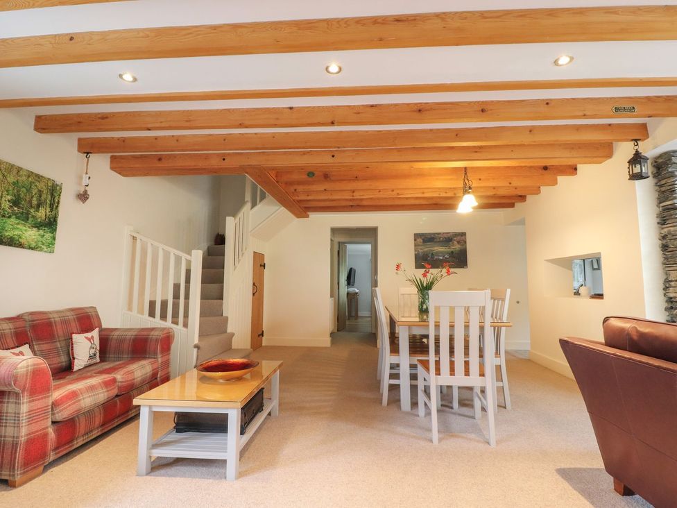 A living room with a sofa and dining area at Bobbin Mill Cottage in Ulverston