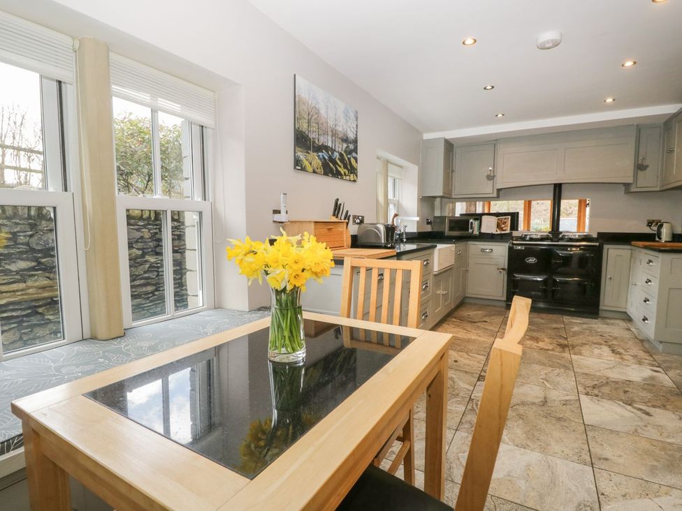 A kitchen with a table and flowers at Bobbin Mill Cottage in Ulverston