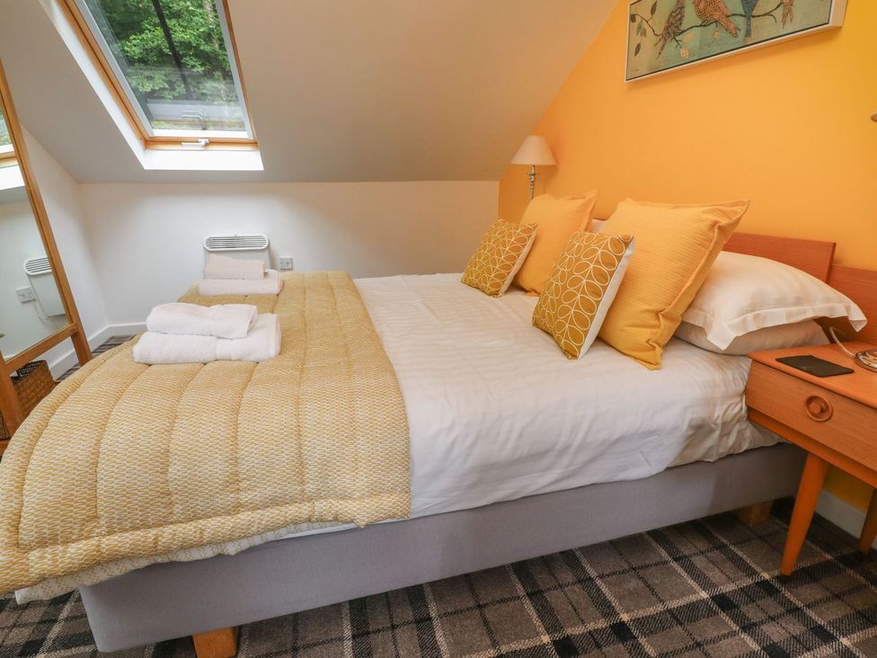 A bedroom with a bed and pillows at Bobbin Mill Cottage in Ulverston