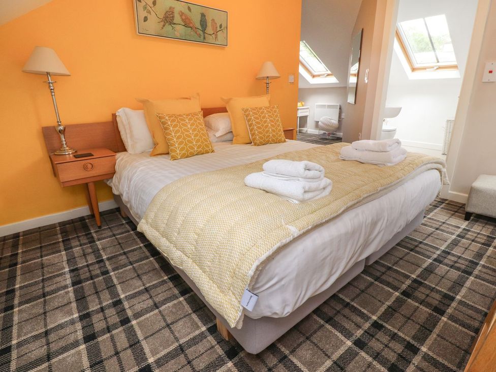 A bedroom with a bed and bedside table at Bobbin Mill Cottage in Ulverston