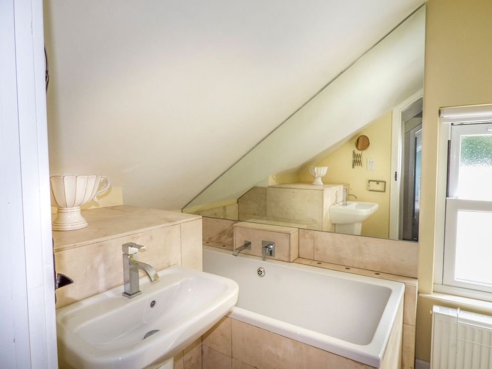 A bathroom with a sink and bath tub at Bobbin Mill Cottage in Ulverston