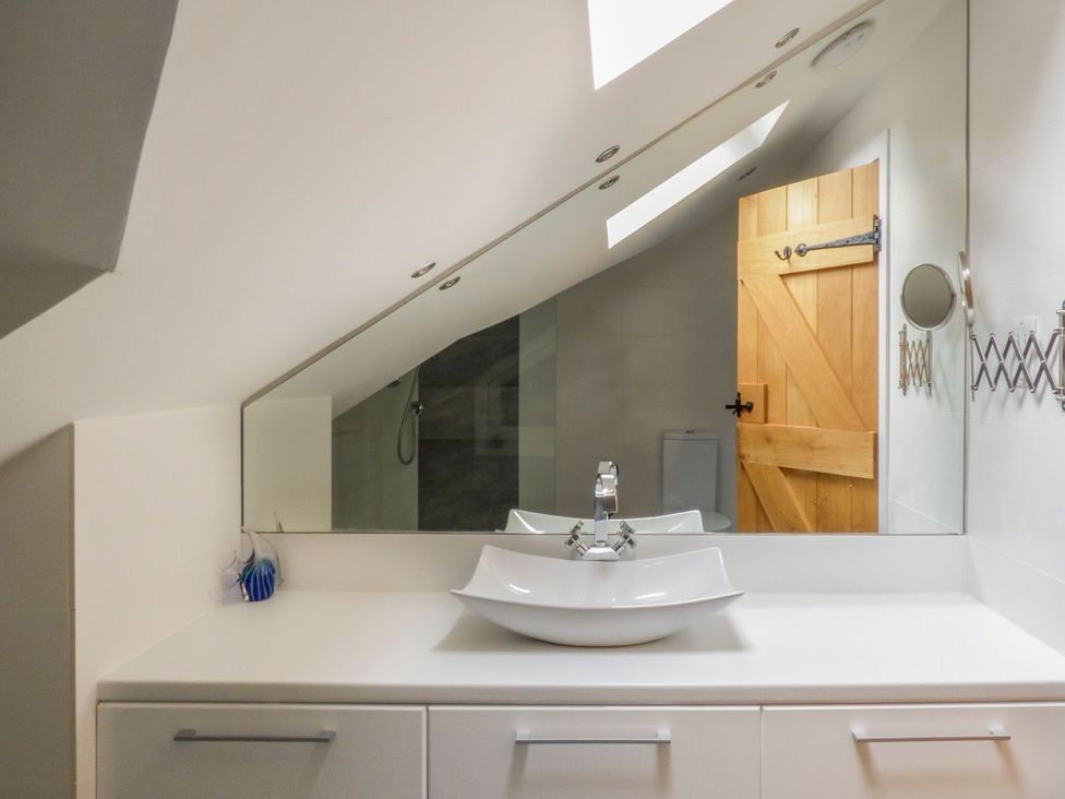 A bathroom with a sink and mirror at Bobbin Mill Cottage in Ulverston