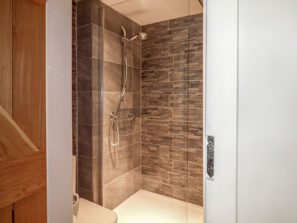 A shower area with tiled walls at Bobbin Mill Cottage in Ulverston