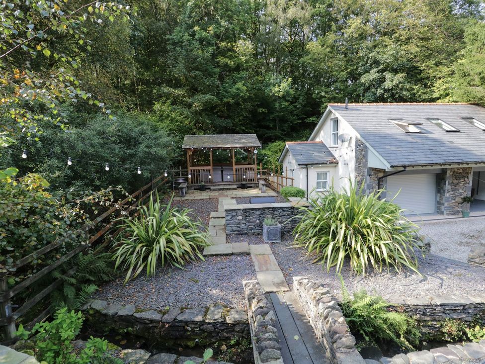 An outdoor area with a gazebo and stone pathway at Bobbin Mill Cottage in Ulverston