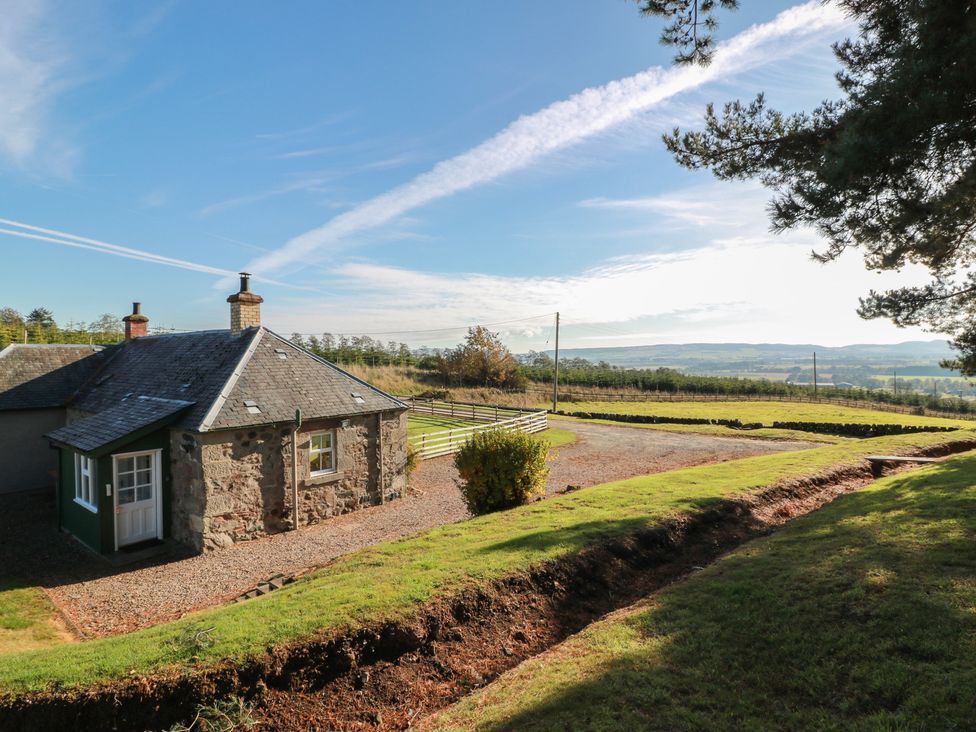 A cottage with a driveway and lawn at Clayhills Cottage Blairgowrie
