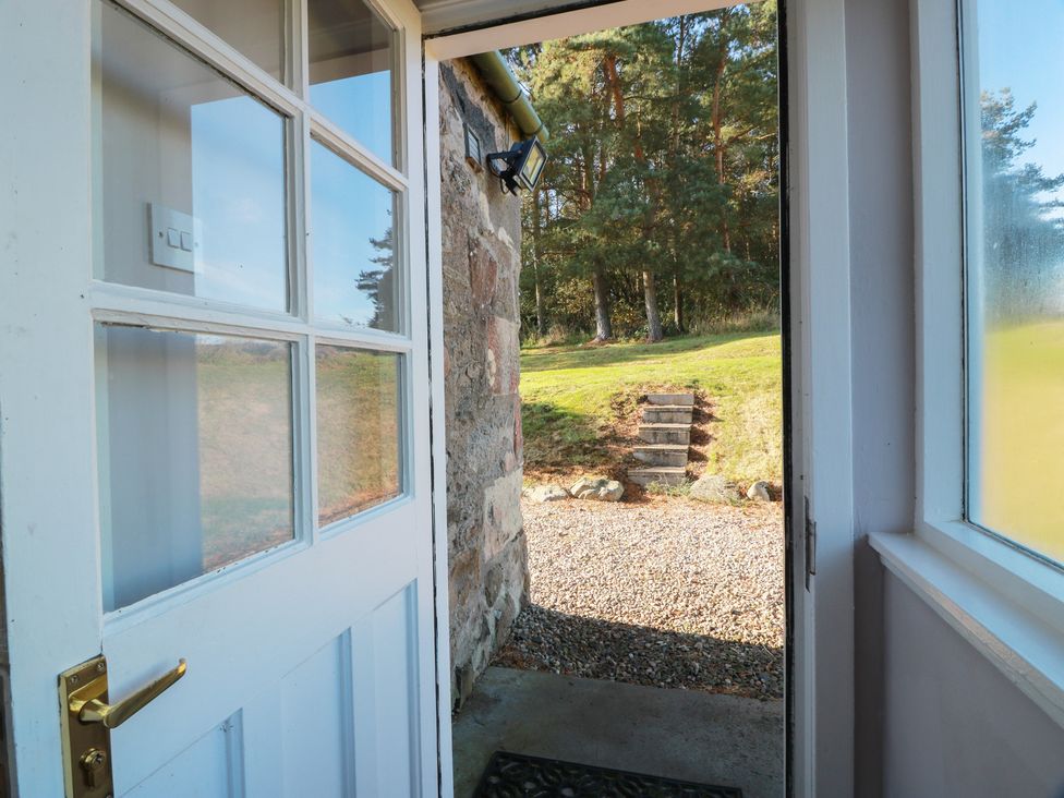 An entryway with a door leading to a stone path at Clayhills Cottage in Blairgowrie
