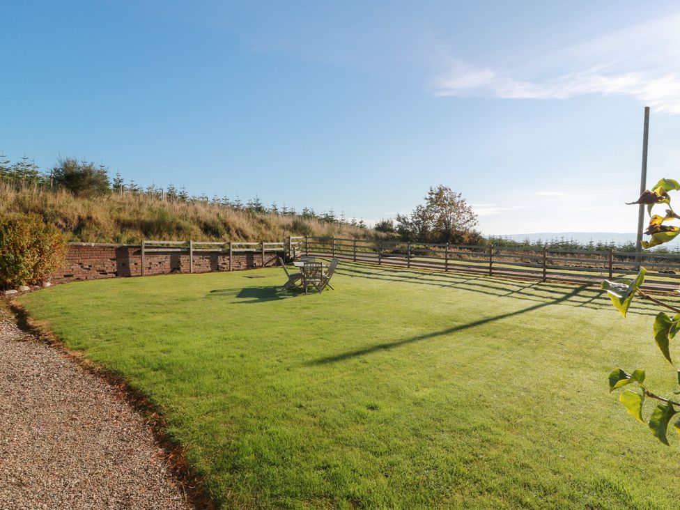 A garden with a fence and furniture at Clayhills Cottage in Blairgowrie