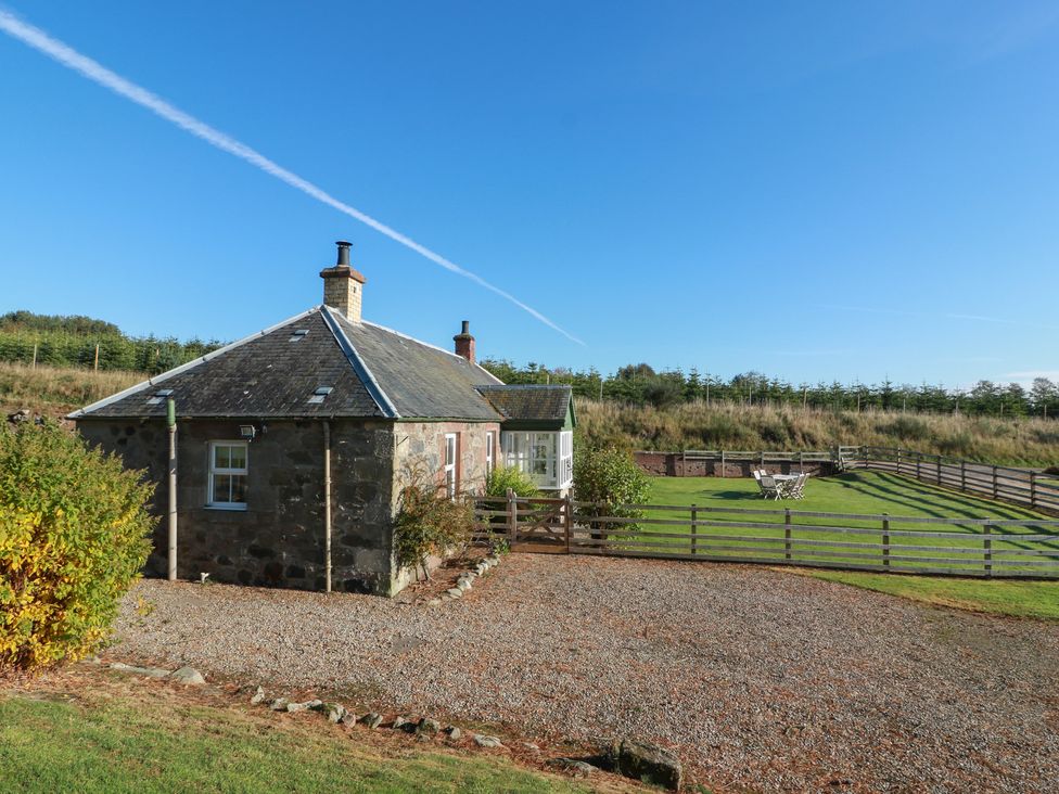 A cottage with a gravel driveway and garden area at Clayhills Cottage Blairgowrie