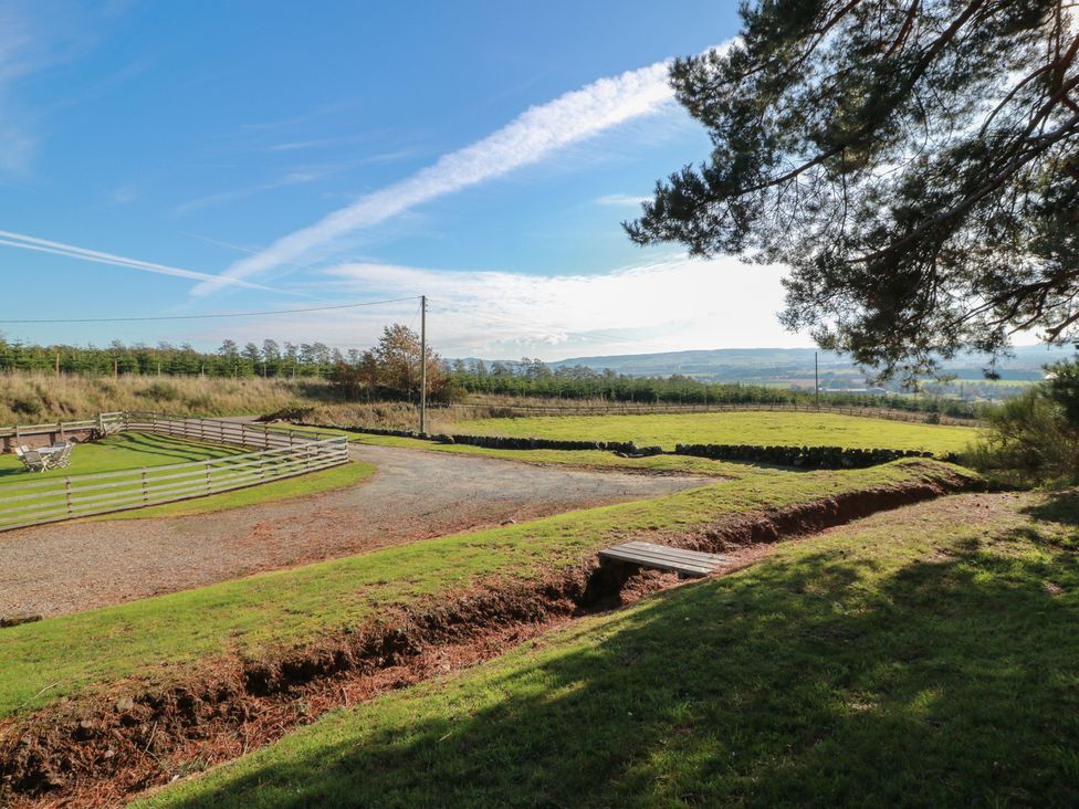 An outdoor area with a fenced section and gravel path at Clayhills Cottage Blairgowrie