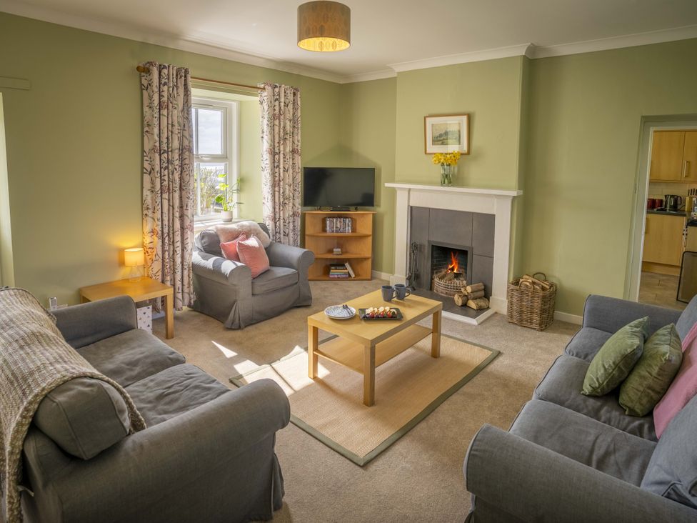 A living room with sofas and a fireplace at Clayhills Cottage in Blairgowrie