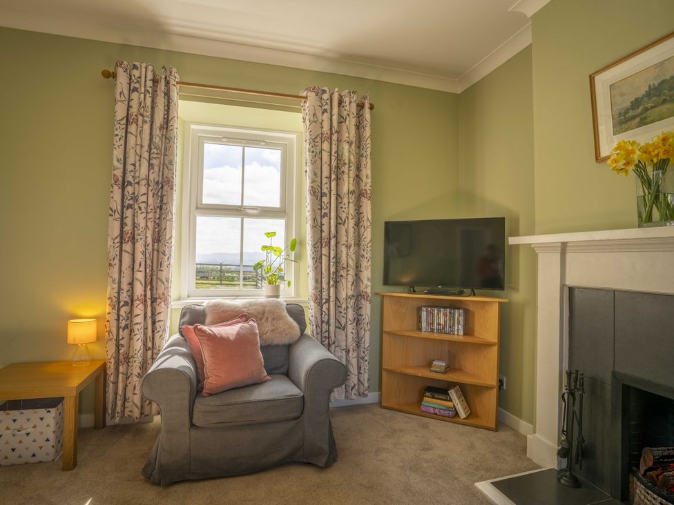 A living room with an armchair and a TV at Clayhills Cottage Blairgowrie