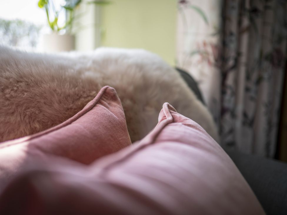 A living room with cushions and a blanket at Clayhills Cottage in Blairgowrie